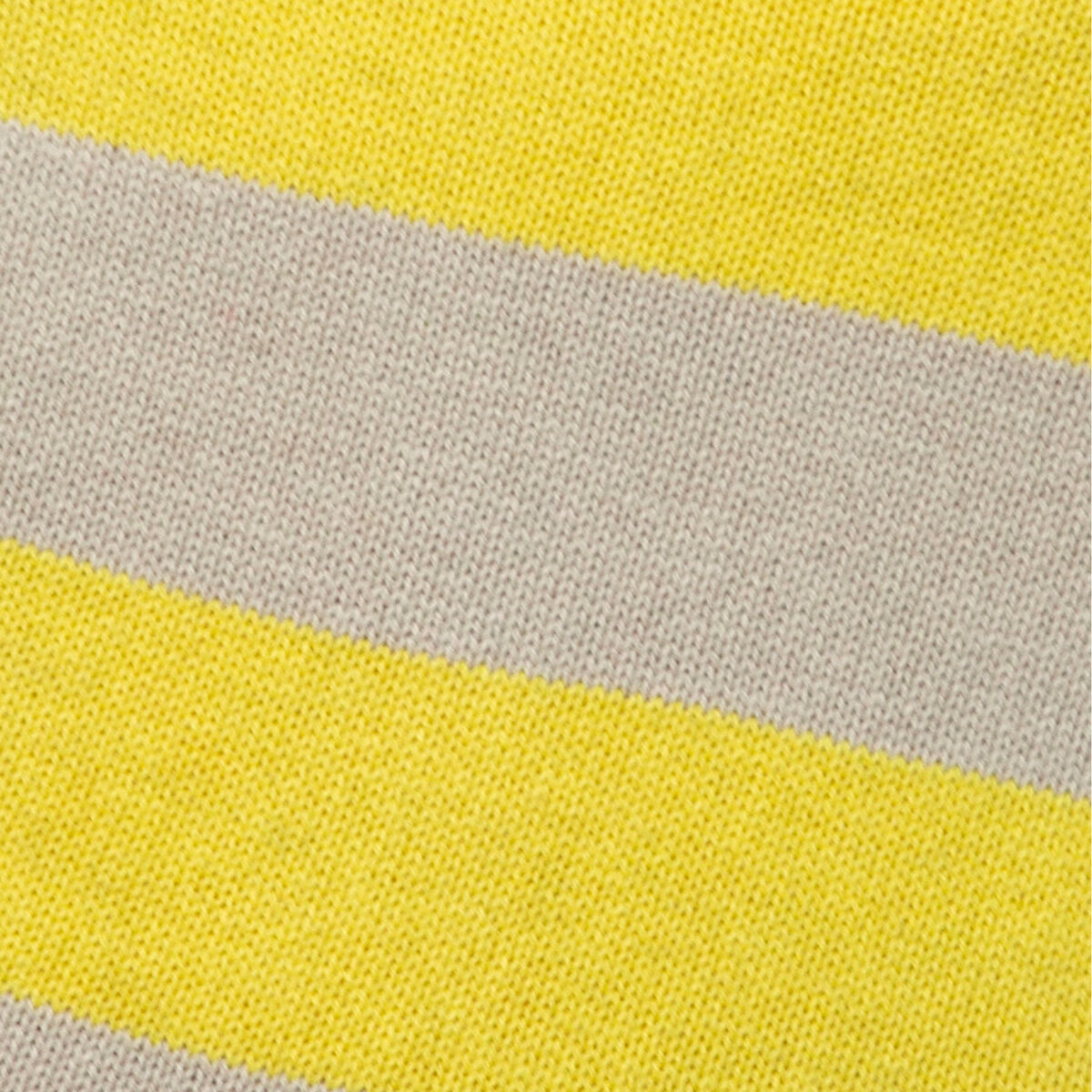 Nahaufnahme des gestrickten Überzugs der SUITE702 Wärmflasche gestreift Gelb. Zu sehen sind breite, abwechselnde Streifen in leuchtendem Gelb und hellem Beige. Die Struktur des Strickstoffs aus 100% Baumwolle ist deutlich sichtbar.
