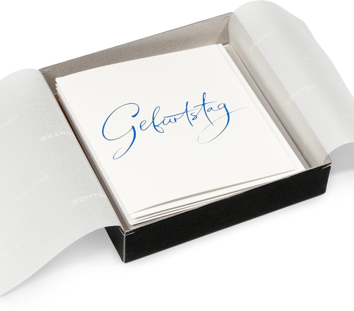 Ein 10-teiliges Set von weißen Geburtstagskarten mit elegantem, blauen Schriftzug 'Geburtstag', präsentiert in einer schwarzen Box mit Schutzpapier.