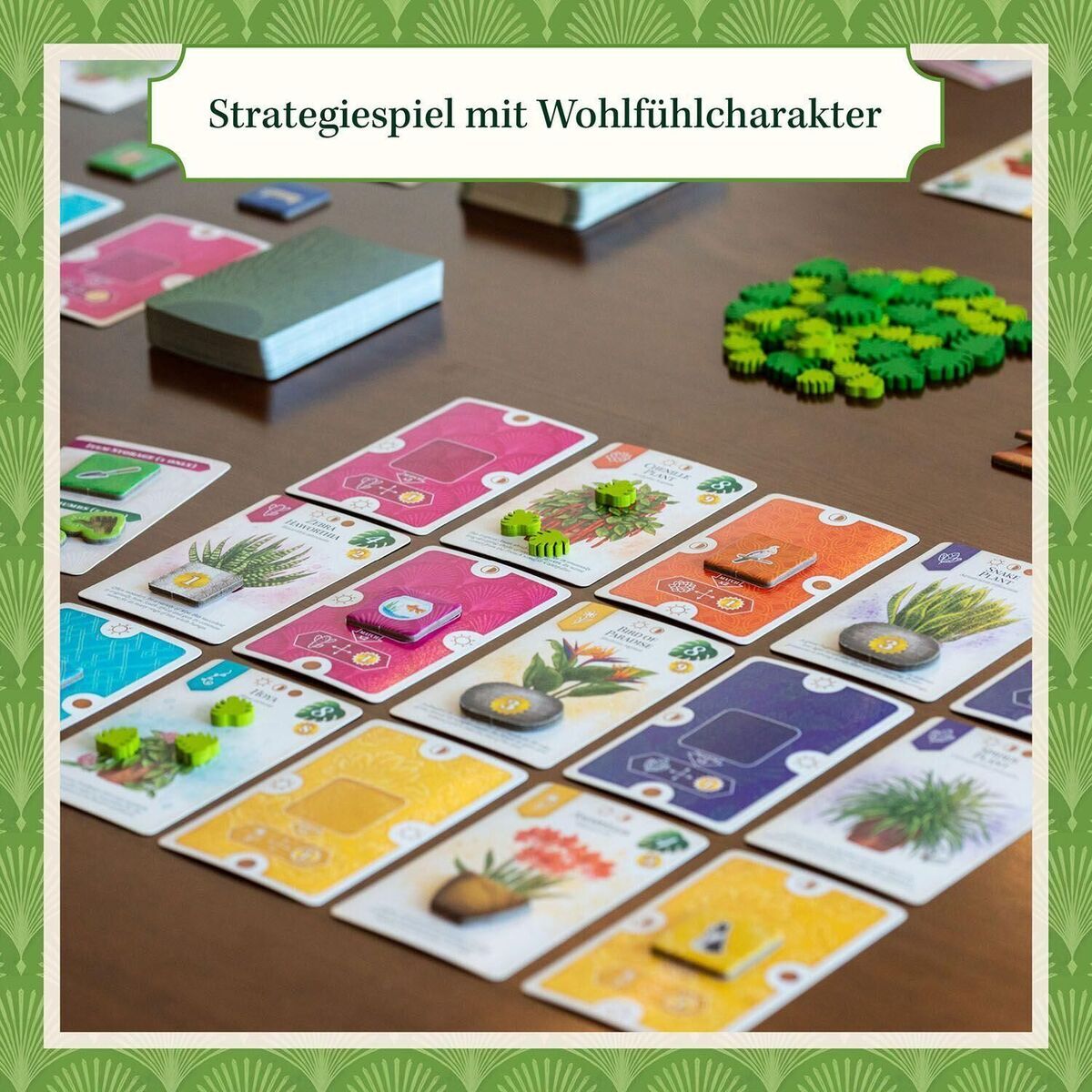 Ein strategisches Brettspiel namens Sattgrün mit Karten, die verschiedene Pflanzen und Zubehör darstellen. Das Spielfeld besteht aus bunten Karten in den Farben Grün, Gelb, Rosa und Weiß, die sorgfältig auf einem Tisch angeordnet sind. Es zeigt verschiedene Elemente des Gärtnerns und hat Figuren in Form kleiner grüner Pflanzen.