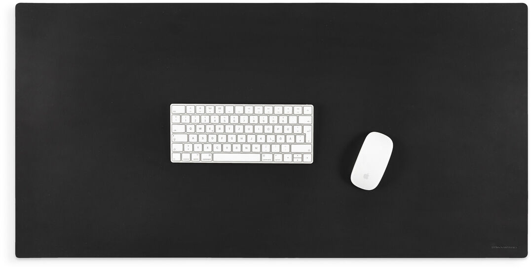 Eine schwarze Schreibtischunterlage mit einer weißen Tastatur und einer weißen Maus darauf. Perfekt für den modernen Arbeitsplatz.