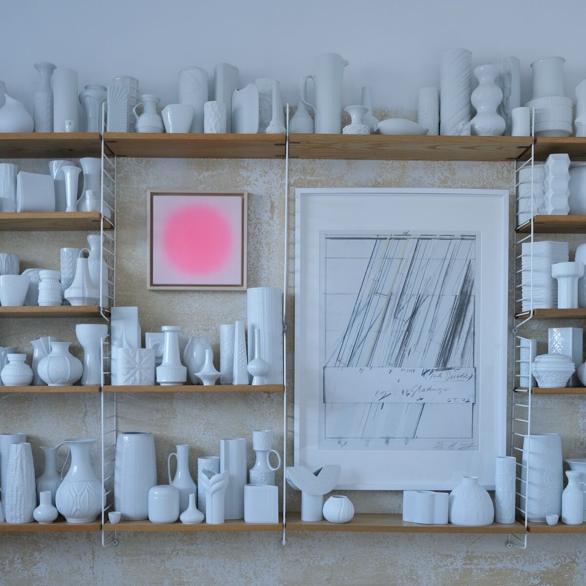 Zu sehen ist ein Kunstwerk der ZEIT-Sonderedition »Sorbet«, Apricot von Studio Anastasia Benko. Das Unikat im Apricot-Ton ist gerahmt und hängt an einer Wand mit weißen Vasen und Gefäßen auf offenen Holzregalen. Im Hintergrund strukturierte, beigefarbene Wand.