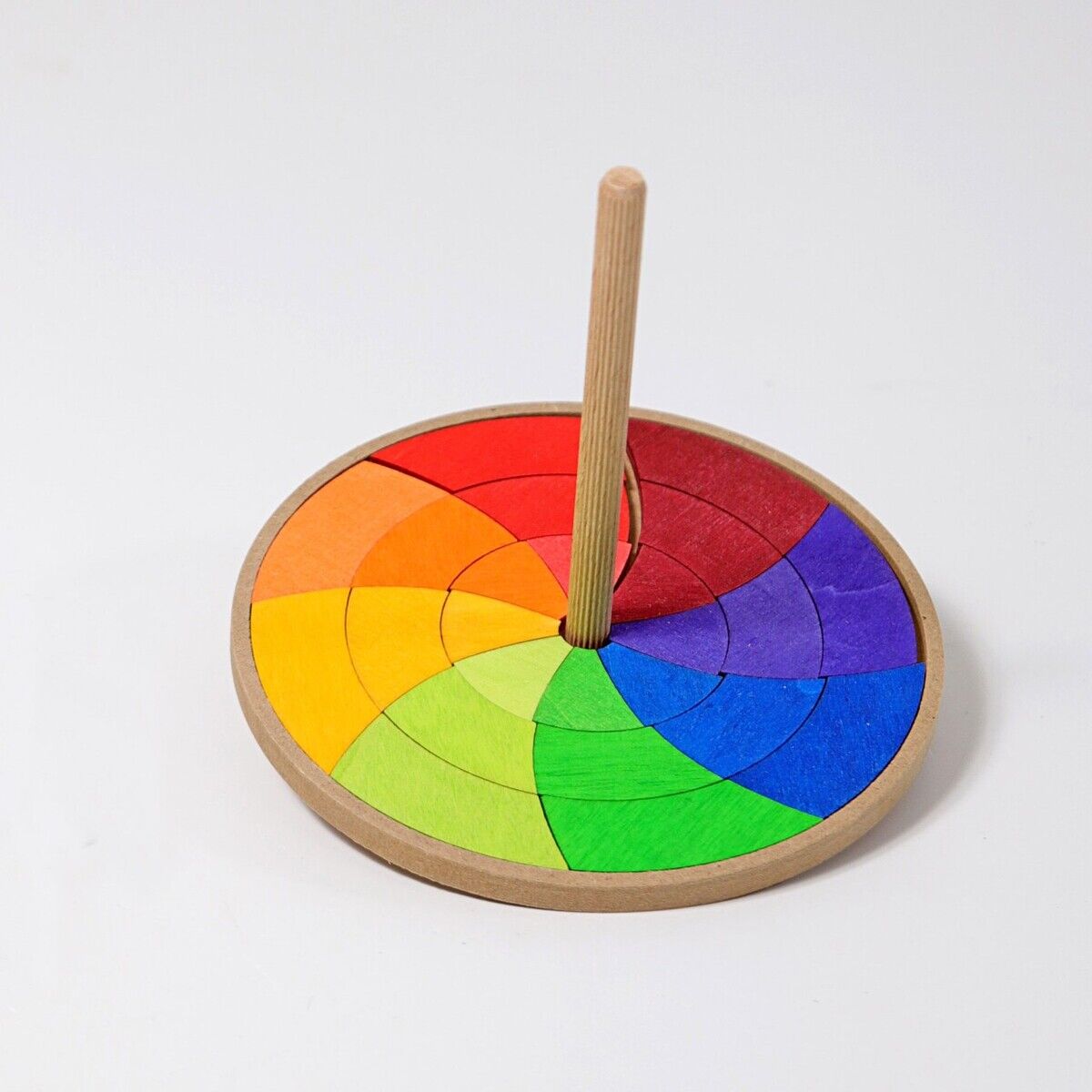Handkreisel aus Holz mit einem farbenfrohen Design in Regenbogenfarben. Perfekt für Kinder als pädagogisches Spielzeug zur Förderung der motorischen Fähigkeiten und Kreativität.