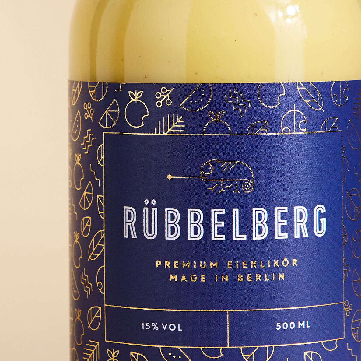 Flasche »Premium Eierlikör« von Rübbelberg mit blauem Etikett und goldener Schrift. Das Etikett zeigt ein stilisiertes Tiermuster.