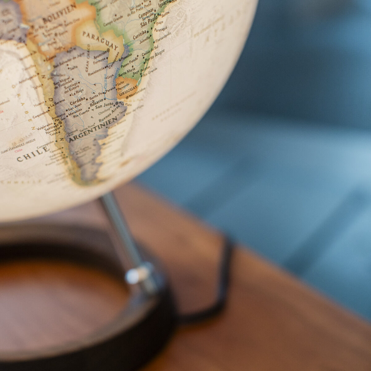 Ein detailreicher Globus der ZEIT-Sonderedition von National Geographic, der auf einem hölzernen Tisch steht. Der Globus zeigt Teile von Südamerika, einschließlich Brasilien und Argentinien. Der Globus hat eine beige Farbgebung und steht auf einem schwarzen Ständer.