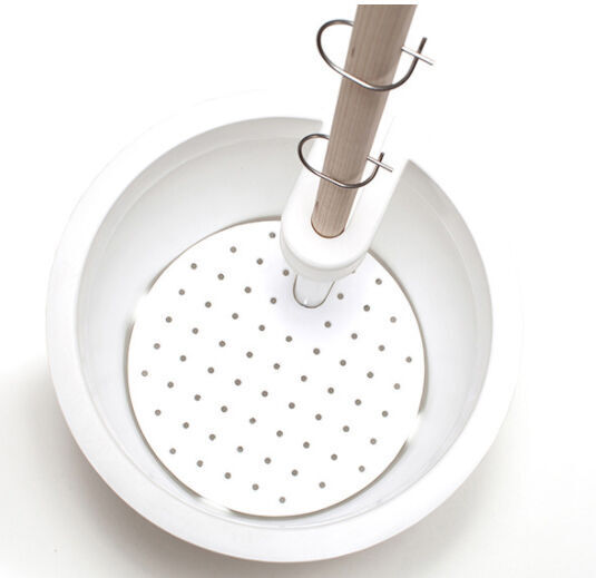 Ein mobiler Pflanzkübel in weiß mit perforierter Basis und einem integrierten Holzstab, ideal für Garten- und Innenpflanzen.