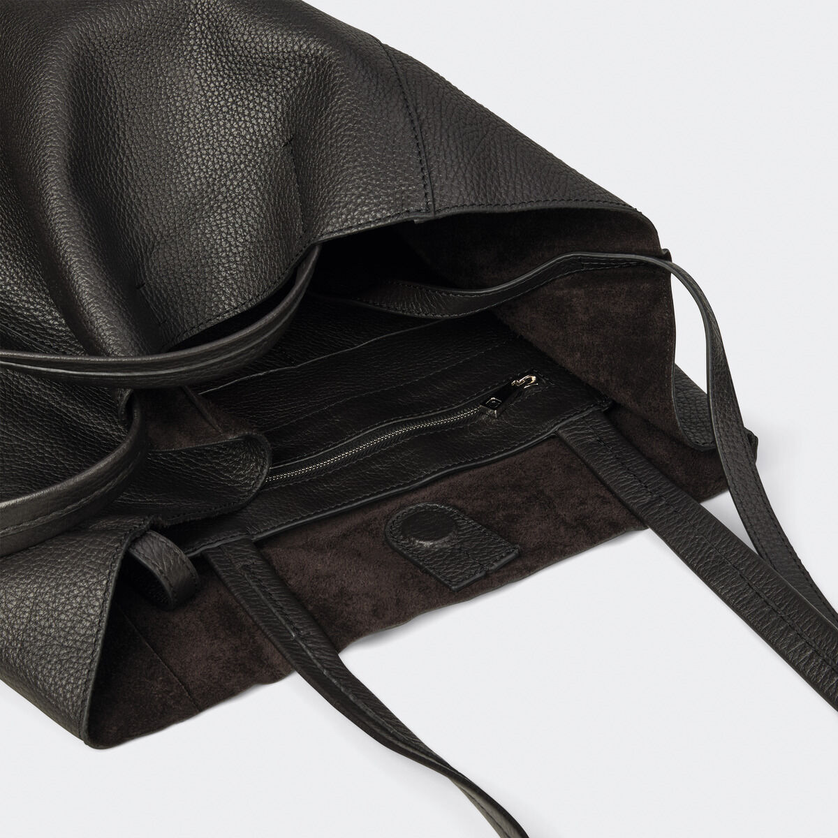Die ZEIT-Tasche »Cep« von Guerer & Guerer in Schwarzbraun ist aus hochwertigem, fein genarbtem Rindsleder gefertigt. Die Tote Bag bietet ein großes Hauptfach, eine herausnehmbare kleine Innentasche mit Zipper und lange, robuste Henkel. Das Innere ist mit dunklem Wildleder ausgekleidet.