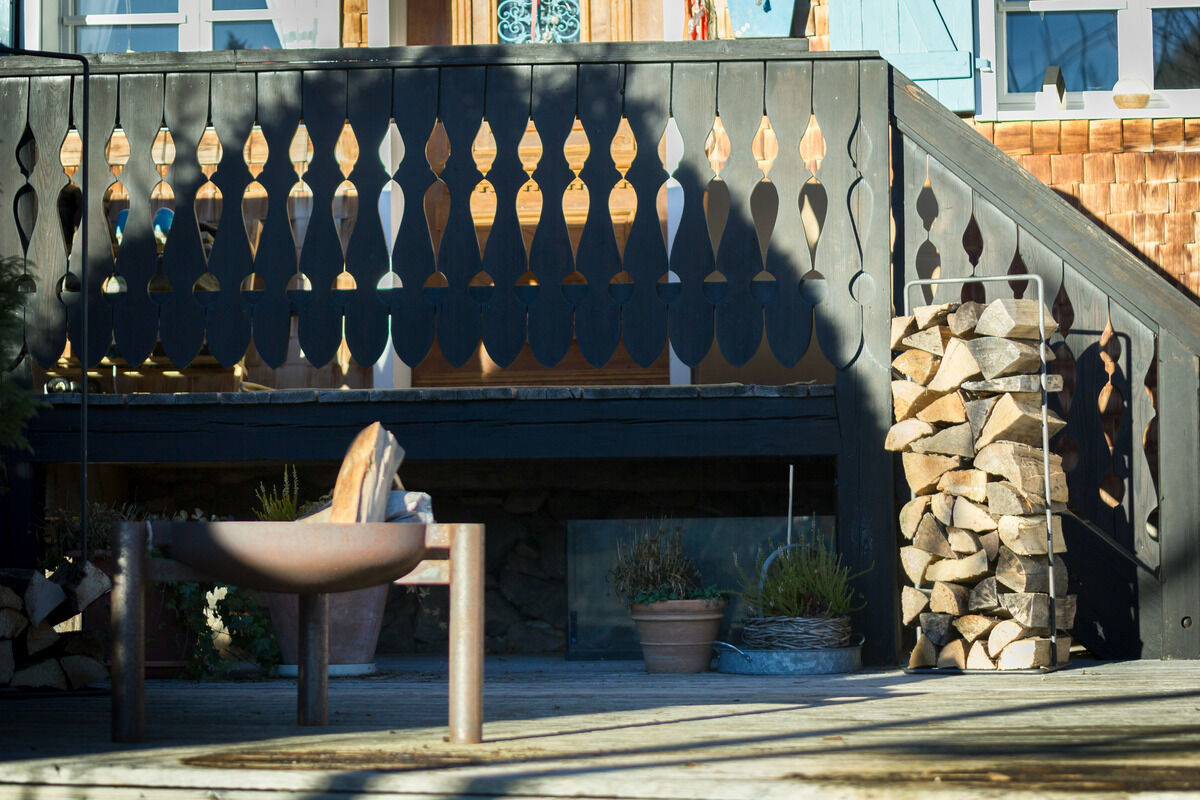Ein stilvolles Kaminholzregal »Timber Frame« im Außenbereich neben einem modernen Grillplatz. Das Holzregal ist gefüllt mit sauber gestapeltem Feuerholz und steht auf einer Terrasse mit rustikaler Dekoration.