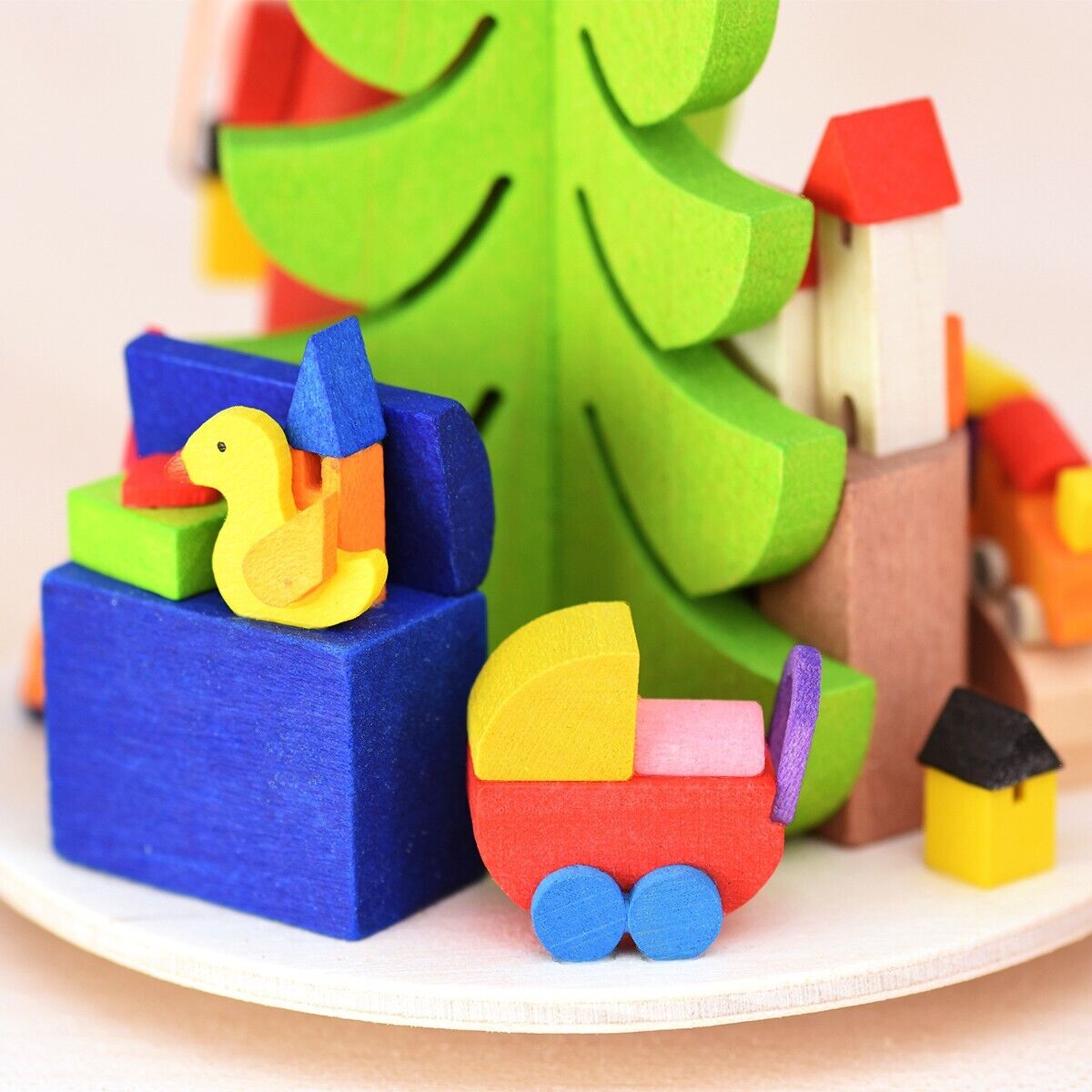 Eine farbenfrohe Teelichtpyramide mit verschiedenen Holzfiguren, darunter ein Weihnachtsbaum, ein Schlitten und Weihnachtsmannfiguren. Die Dekoration ist in gedämpften Farben wie Grün, Rot, Blau, Gelb, Orange und Braun gehalten und eignet sich hervorragend zur festlichen Weihnachtsdekoration.