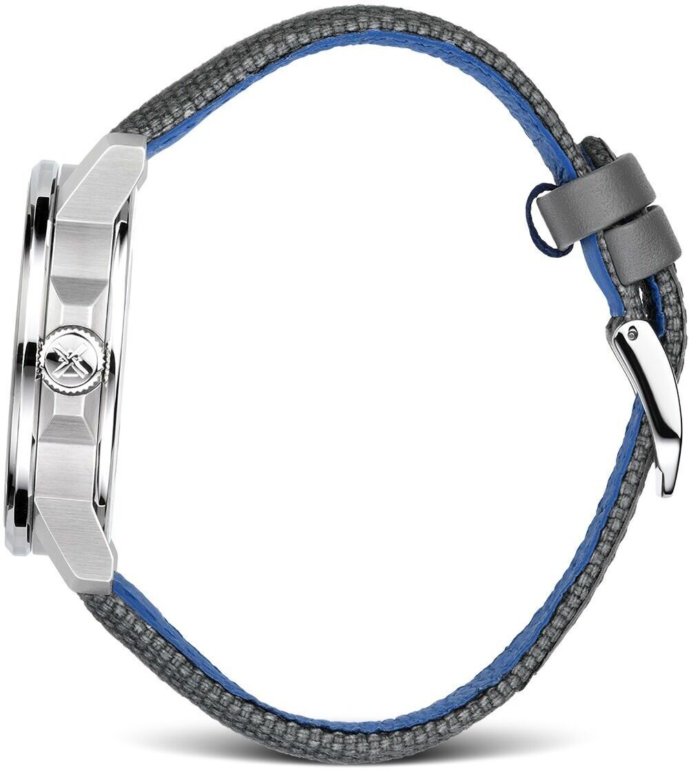 Ein Bild der ZEIT-Sonderedition »29er Big« (2019) von Mühle-Glashütte. Die Uhr hat ein Edelstahlgehäuse und ein graues Lederarmband mit blauer Innenseite. Das Gehäuse zeigt das markante Logo von Mühle-Glashütte.