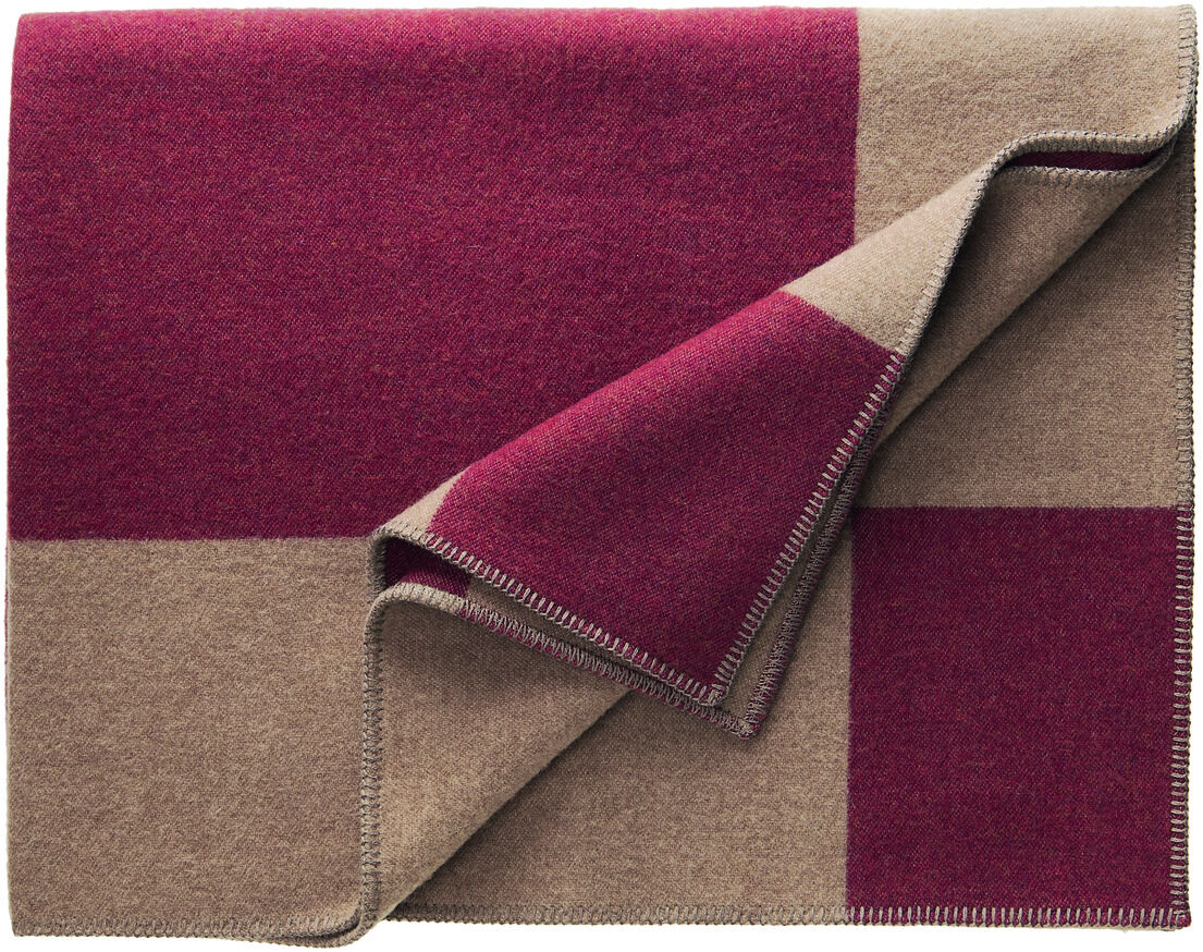 Eine Decke mit dem Namen 'Manchester' in Bordeaux und Beige mit großem Karomuster, gefaltet und mit sichtbaren Nähten an den Rändern.