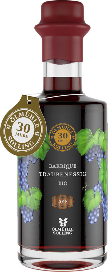 Glasflasche mit bordeauxrotem Wachssiegel, gefüllt mit Barrique Traubenessig von Ölmühle Solling. Etiketten in Gold und Schwarz, Verzierungen mit grünen Weinblättern und lilafarbenen Trauben, Jubiläumsanhänger „30 Jahre Ölmühle Solling“ am Flaschenhals.