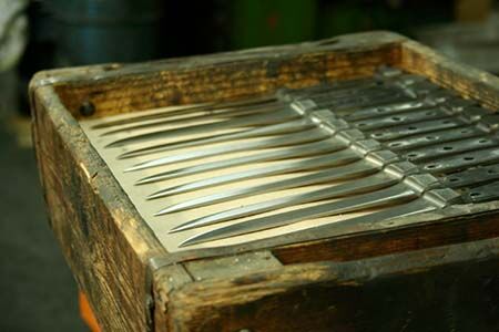 Mehrere lange, spitze Metallstäbe in einem alten Holzrahmen angeordnet