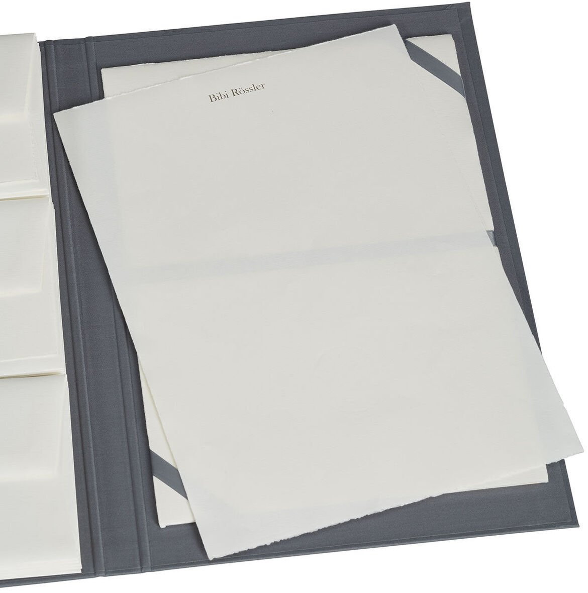 Eine geöffnete Briefpapiermappe mit edlem Büttenpapier. Die Mappe enthält mehrere Fächer für Papier und Umschläge. Das Papier ist elegant und hochwertig.