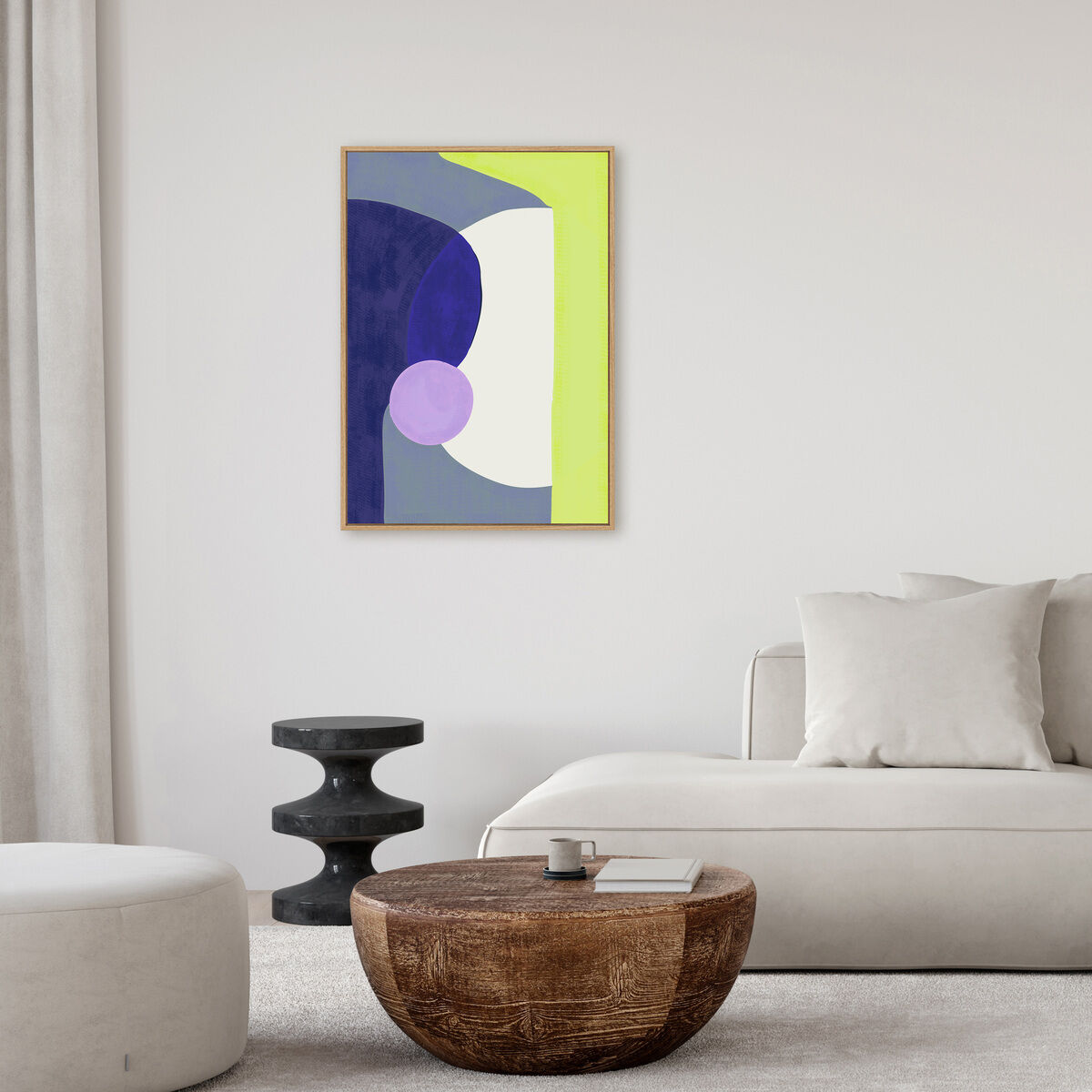 Abstraktes Leinwandbild mit geometrischen Formen in Violett, Dunkelblau, Gelbgrün, Weiß und einem Hauch Hellbraun in einem modernen Wohnzimmer mit heller Einrichtung, rundem Hocker, minimalistischem Couchtisch und Sofa.