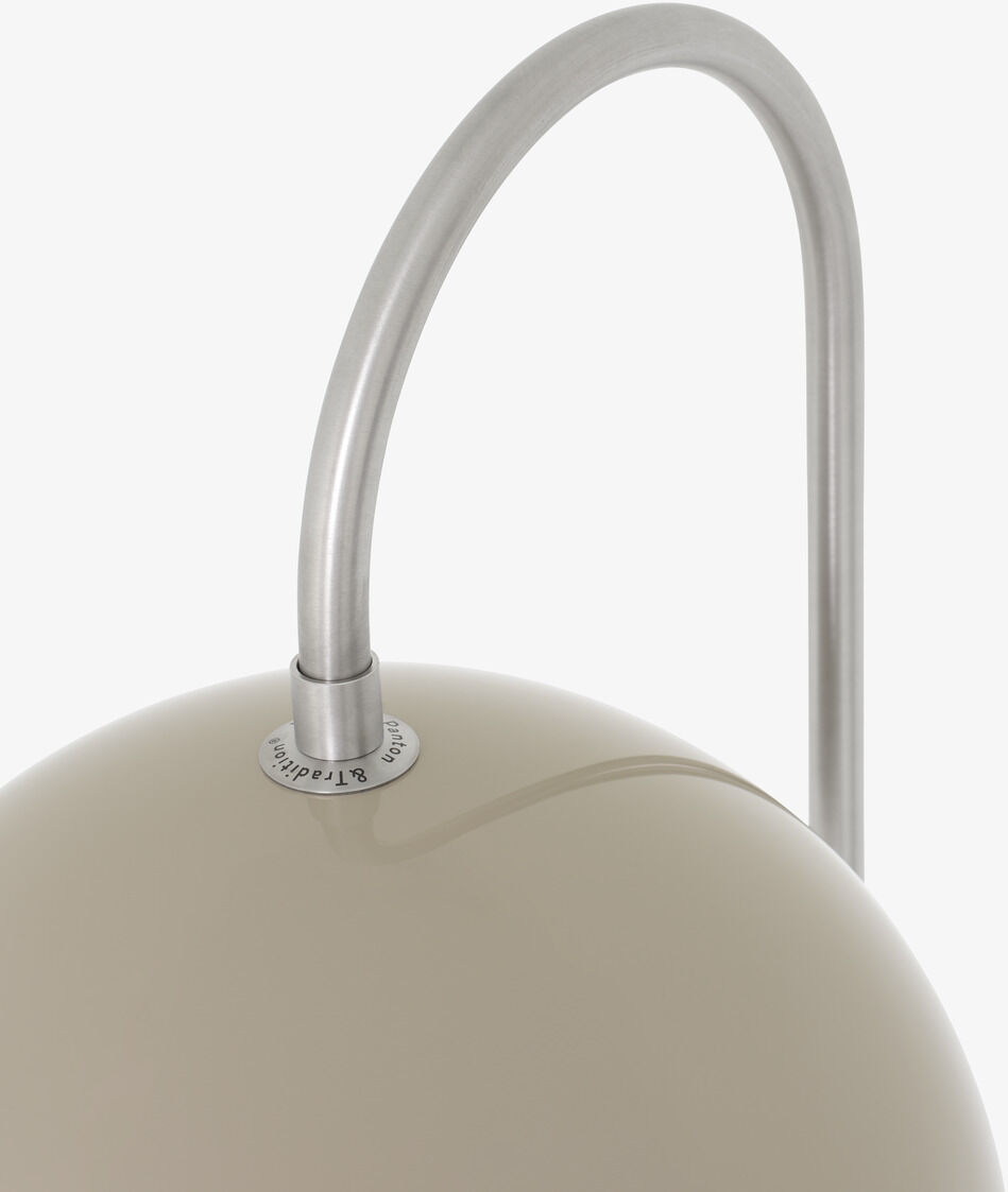 Das Bild zeigt einen modernen Blumentopf des Typs Flowerpot VP12 in Beige mit silbernem Metallbogen im minimalistischen Design.