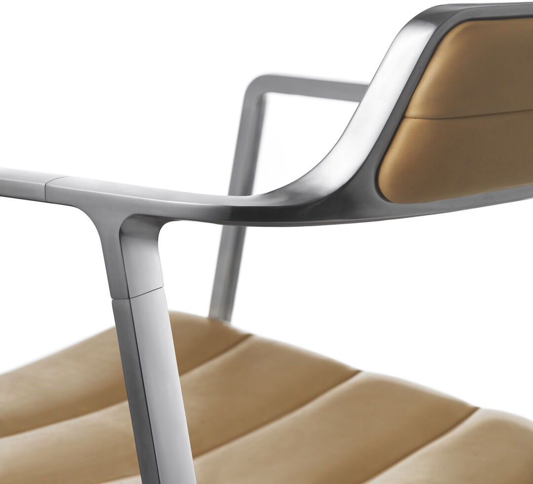 Ein moderner Bürostuhl der Marke Vipp, Modell »Swivel« in der Farbe Cognac. Der Stuhl hat einen gepolsterten Ledersitz und Rückenlehne, sowie Aluminiumrahmen.