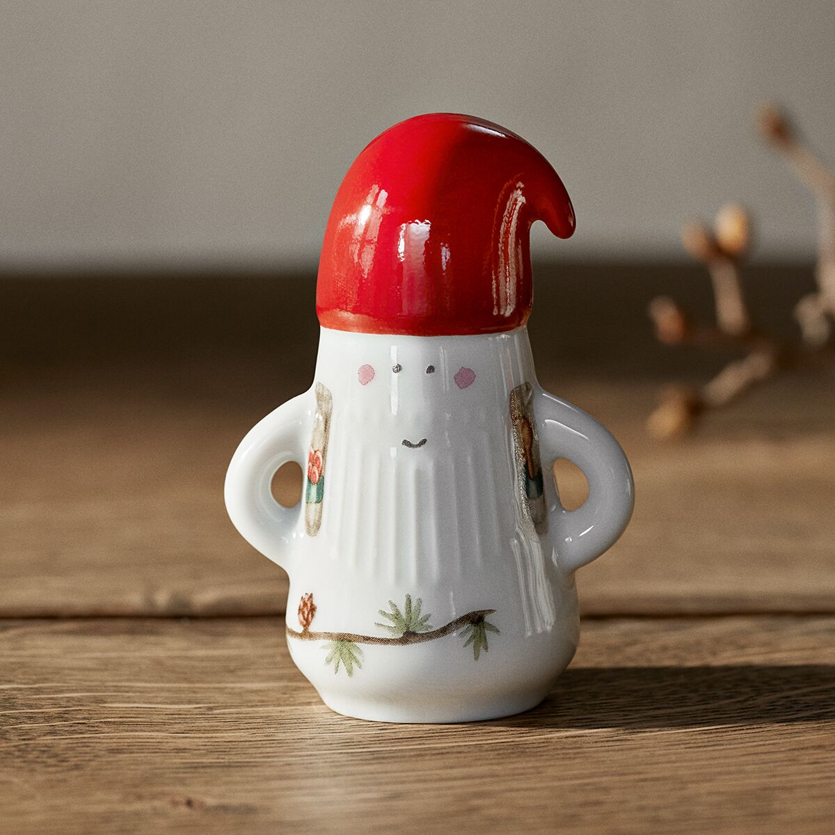 Porzellanfigur eines Weihnachtsmannes aus der Serie Hammershøi von Kähler, mit roter Mütze, weißem Körper und feinen, handbemalten Details auf einem Holztisch; warme, festliche Stimmung.