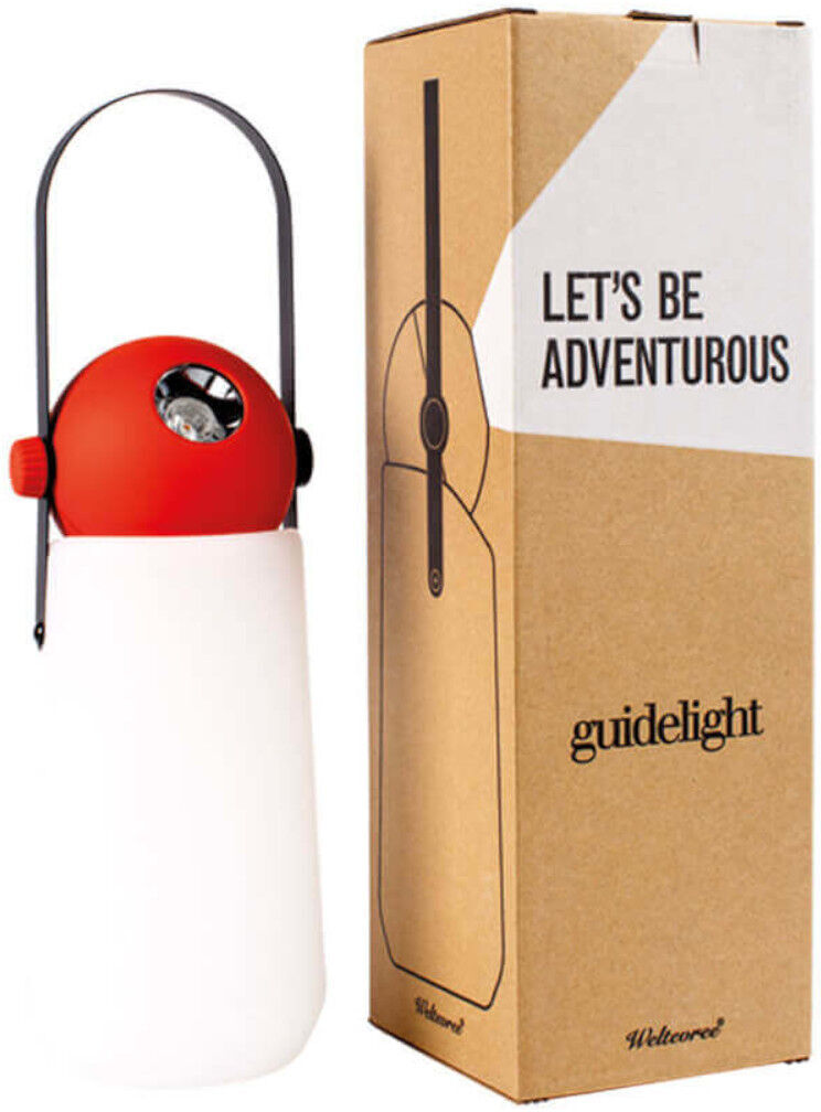 Das Bild zeigt eine tragbare Lampe namens »Guidelight«, die eine Kombination aus rotem, weißem und schwarzem Design aufweist. Sie steht neben einer braunen Verpackung mit der Aufschrift 'LET'S BE ADVENTUROUS' und 'guidelight'.