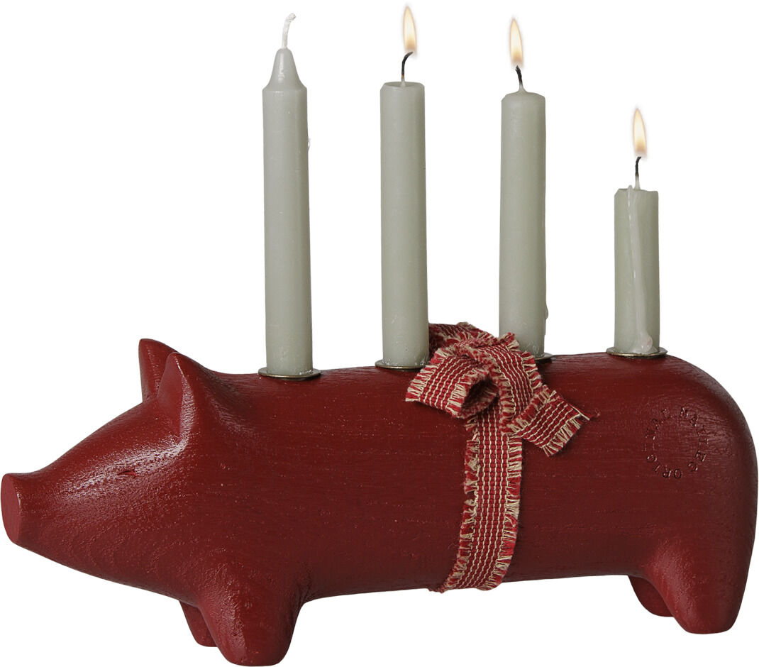 Roter, mittelgroßer Kerzenhalter in Form eines Schweins aus Holz von Maileg. Auf dem Rücken befinden sich vier brennende, graue Kerzen. Eine rote Stoffschleife ist um das Schwein gebunden. Das Design ist verspielt, festlich und dekorativ.