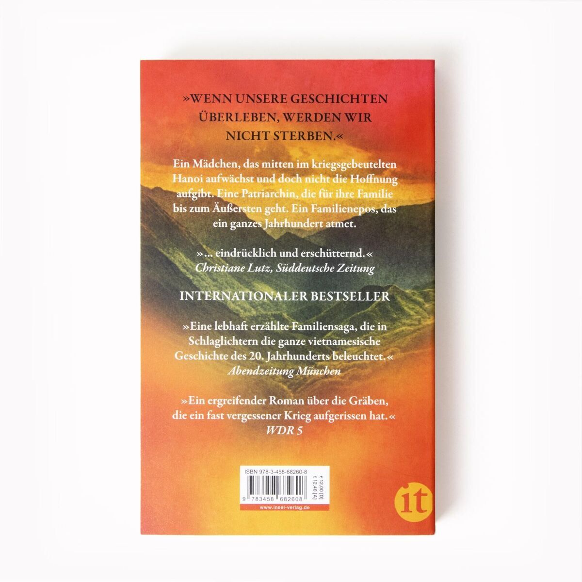 Das Buch 'Der Gesang der Berge' von Nguyen Phan Que Mai präsentiert sich mit einem farbenfrohen Buchrücken. Die dominierenden Farben sind Orange, Rot und Gelb, und darauf sind zusammenfassende Texte und Kritiken zu finden. Das Buch beschäftigt sich mit einer Familiengeschichte in der Nachkriegszeit in Vietnam.