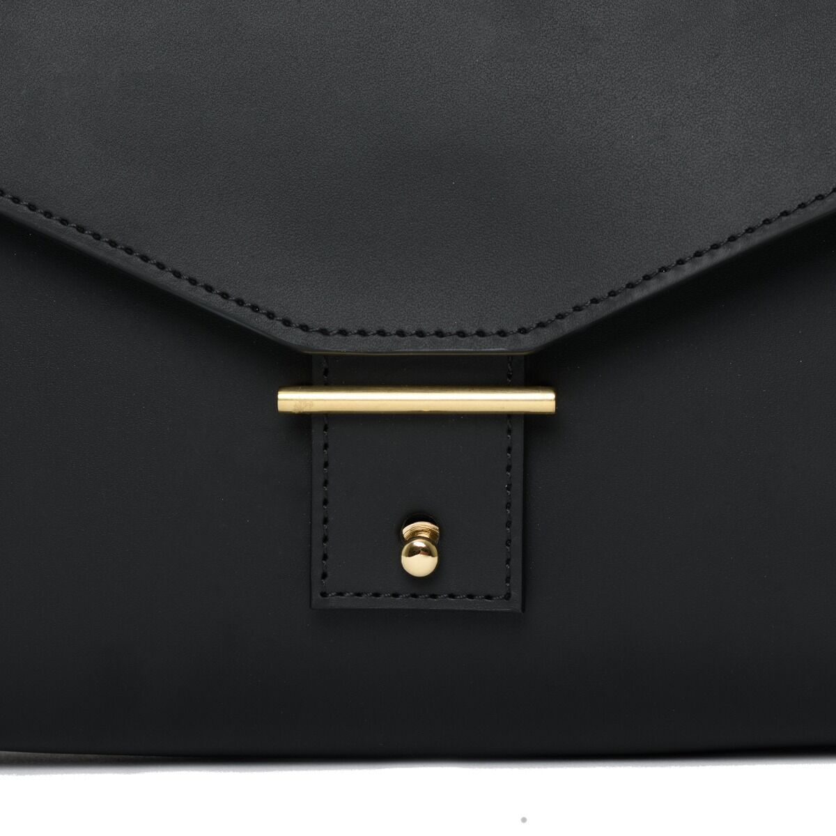 Schwarze Schultertasche aus Leder mit goldfarbenem Verschluss, minimalistischem und modernem Design. Sonderedition von DIE ZEIT.