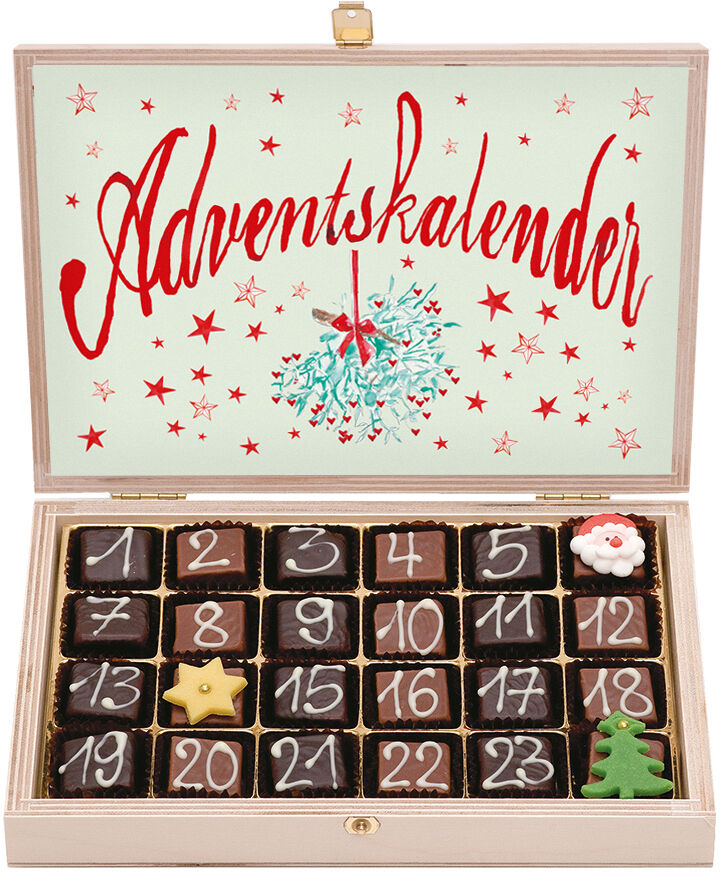 Ein Adventskalender in Form einer Schachtel mit 24 nummerierten Fächern, die mit verschiedenen Nougatpralinen gefüllt sind. Auf der Innenseite des Deckels steht groß das Wort 'Adventskalender' in roter Schrift, umgeben von Sternen, und es ist ein Tannenbaum abgebildet.