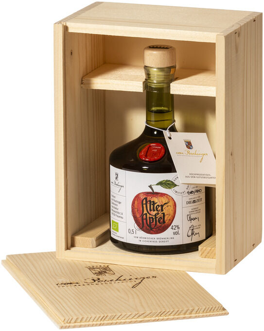Eine Flasche ZEIT-Sonderedition »Alter Apfel« Edelbrand in einer geöffneten Holzkiste. Die Flasche hat ein Etikett mit einem roten Apfel und der Schriftzug 'Alter Apfel'. Die Holzkiste ist hellbraun und detailliert gearbeitet.