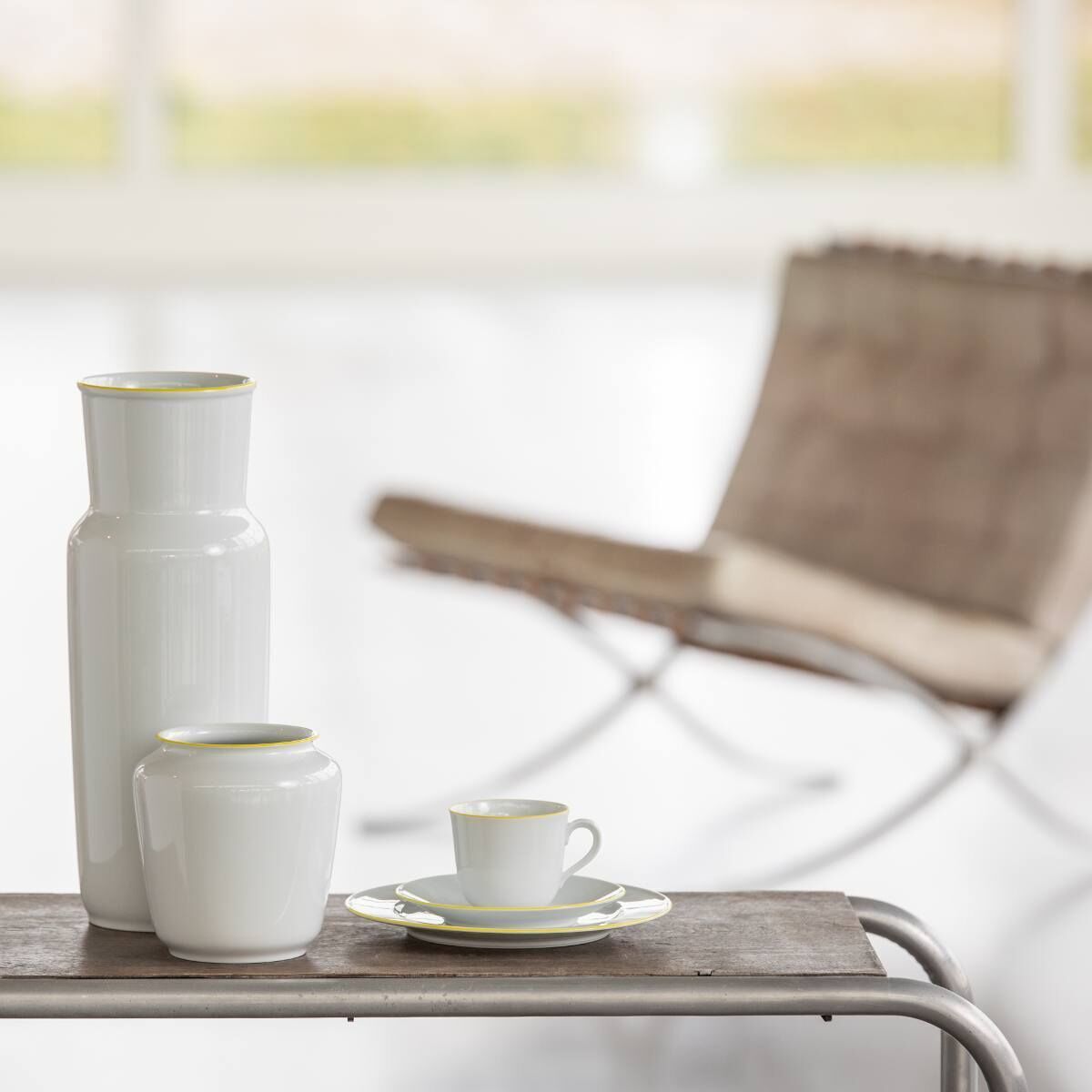Weißes, minimalistisch designtes, hochglanzpoliertes Vasen-Set von Wagenfeld für Fürstenberg, präsentiert auf einem rustikalen Holztisch. Perfekte Kombination aus klassischem und modernem Stil.