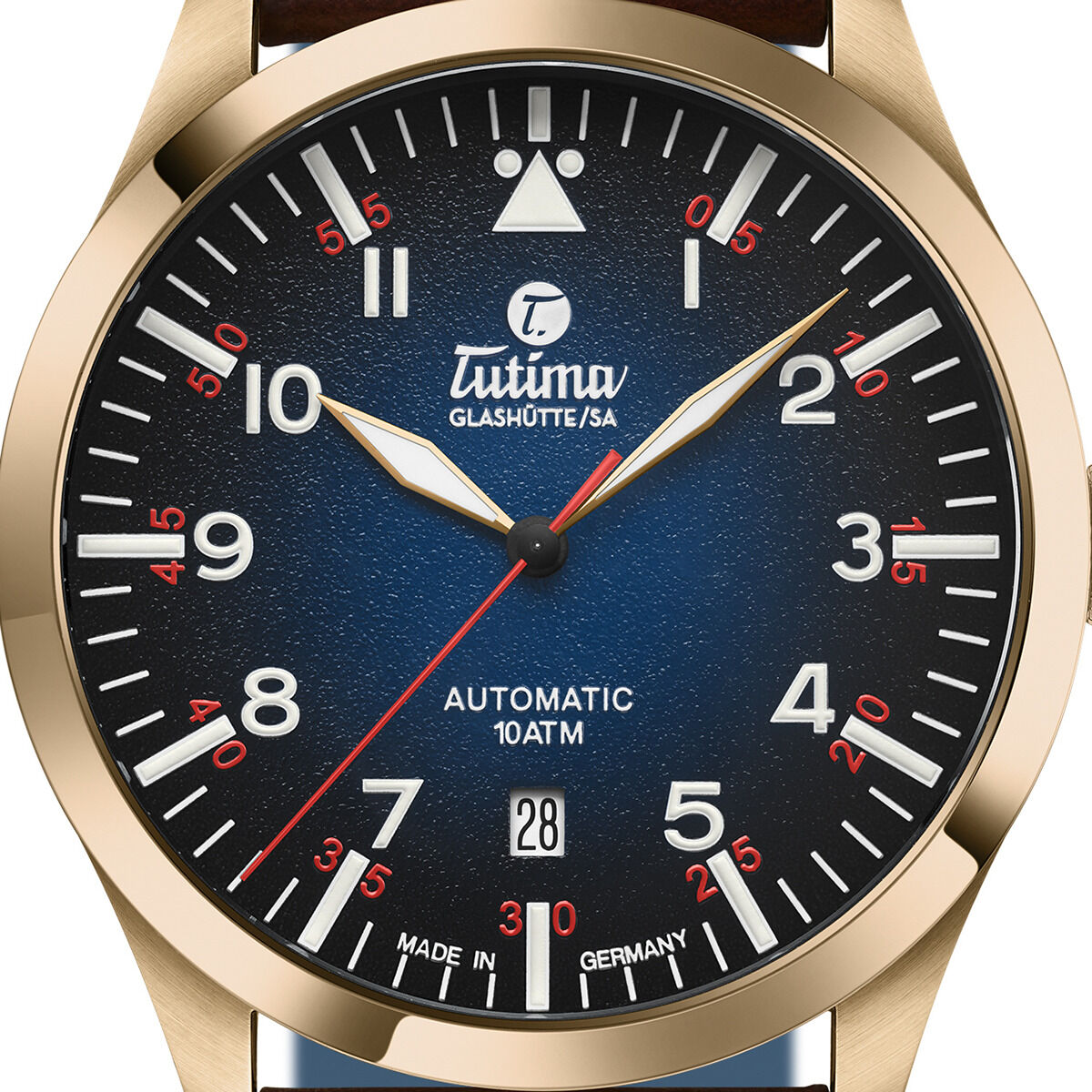 Eine Fliegeruhr mit Bronzegehäuse und Automatikwerk. Das Zifferblatt ist dunkelblau mit weißen und roten Zahlen sowie goldenen Zeigern. Das Datum ist bei der Position 6 Uhr sichtbar. Die Uhr hat ein Lederarmband.