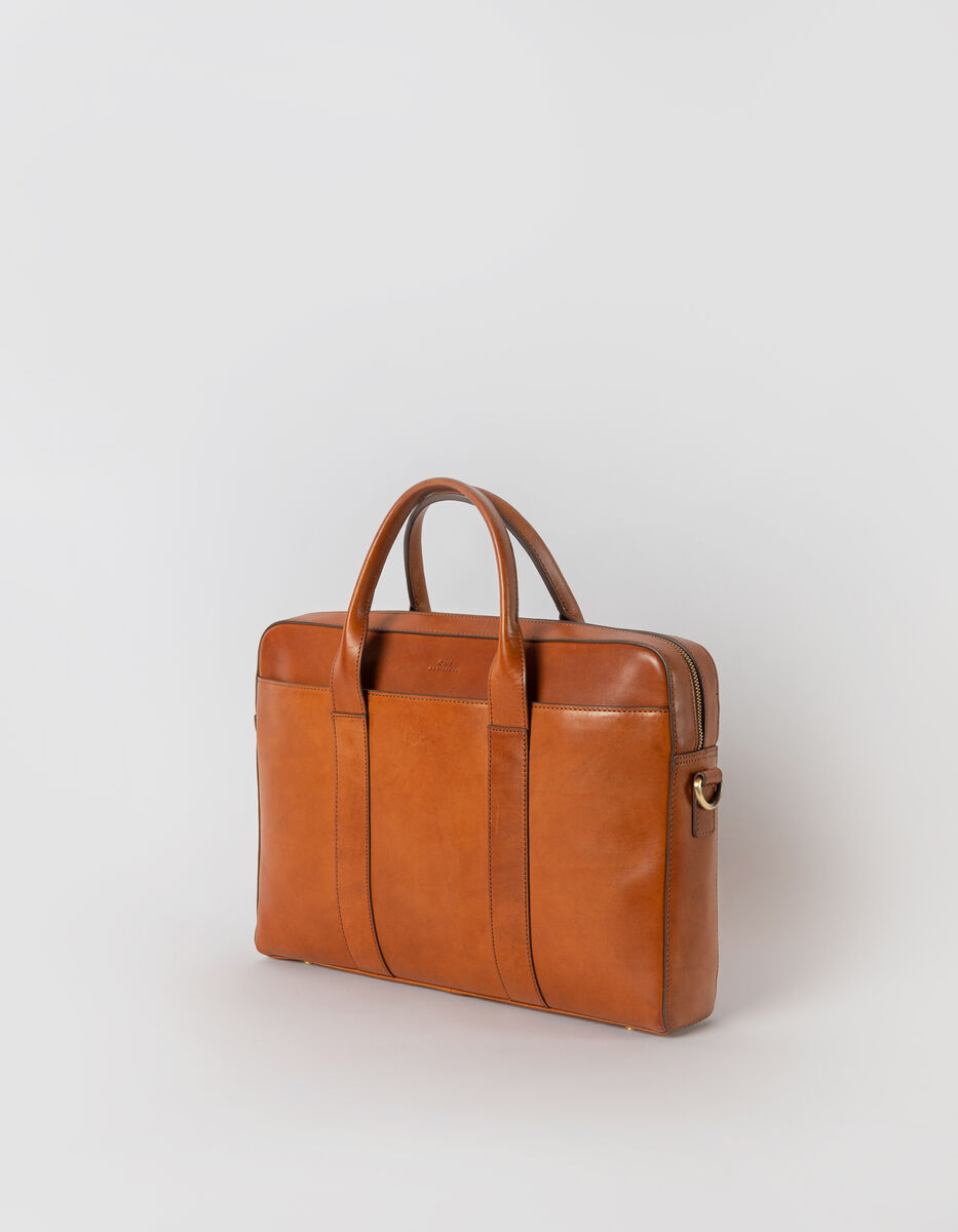 Braune Ledertasche des Modells 'Harvey' vor grauem Hintergrund. Die Tasche ist eckig mit zwei Griffen und einem goldfarbenen Reißverschluss.