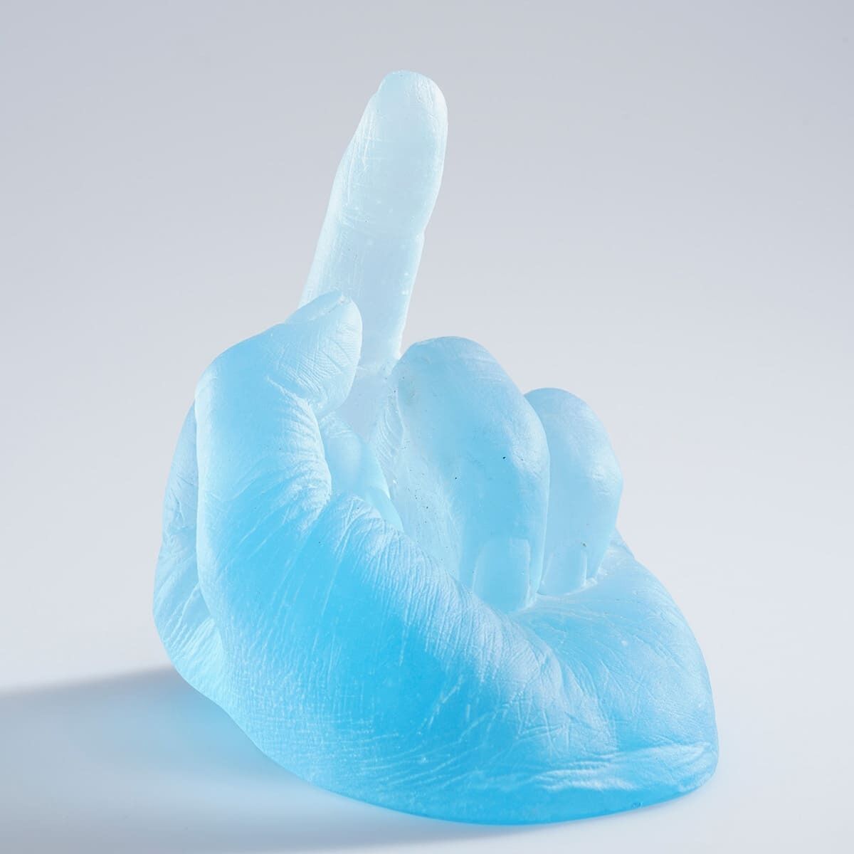 Eine blaue Hand-Skulptur aus Glas von Ai Weiwei, die den mittleren Finger zeigt. Das Kunstwerk ist detailliert und vermittelt eine moderne, provokative Botschaft.