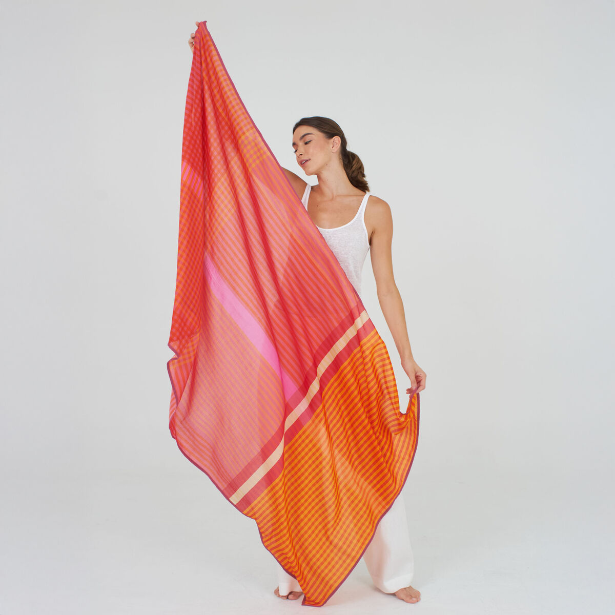 Der Baumwoll-Seidenschal »Willa« von Shalls Barcelona ist groß und leicht transparent, überwiegend orange mit sanften creme- und weißen Akzenten. Feine Webstruktur, weicher, fließender Stoff, zarte Fransen an den Rändern, elegant im Faltenwurf präsentiert.