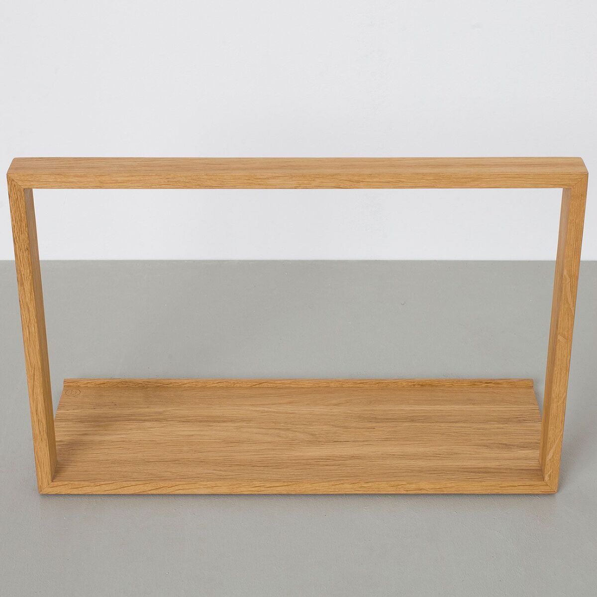 Ein minimalistischer Plattenständer aus Holz für die Aufbewahrung von Schallplatten, genannt »B-Seite«. Das Möbelstück ist rechteckig und hat eine einfache, moderne Konstruktion.