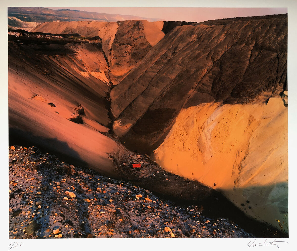 Fotografie von Wackerbarth mit dem Titel „Garzweiler 1998“. Das Bild zeigt eine großflächige Tagebaulandschaft mit steilen, erodierten Erdschichten in Brauntönen und Schwarztönen, dominiert von erdigen und dunklen Farben, die die industrielle Ausbeutung und Rohheit der natürlichen Umgebung unterstreichen.
