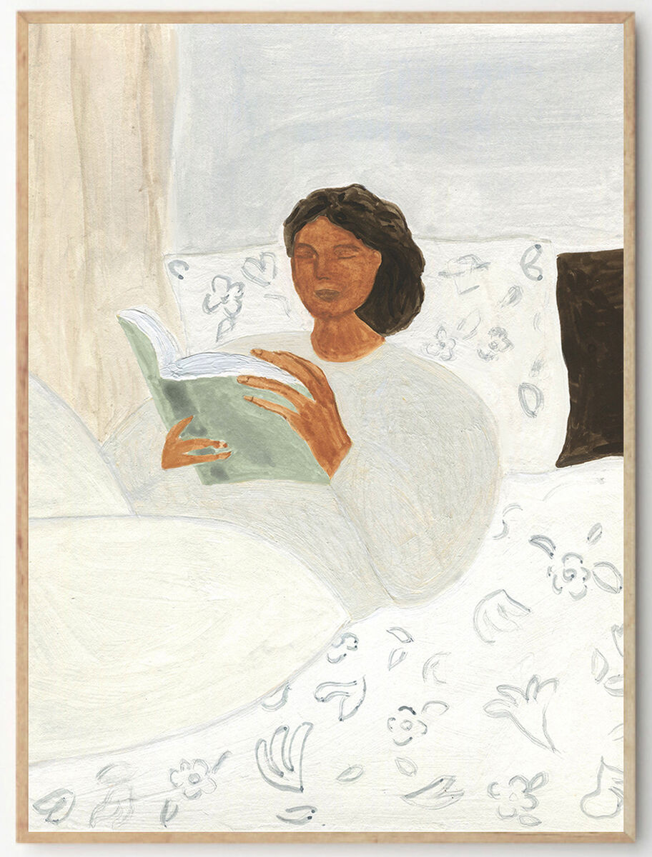 Ein Kunstwerk zeigt eine Frau, die gemütlich in einem Bett liegt und in einem Buch liest. Die Farben sind überwiegend in Weiß, Braun und Grün gehalten. Der Rahmen des Bildes ist schlicht und passend zu einem modernen Einrichtungsstil.