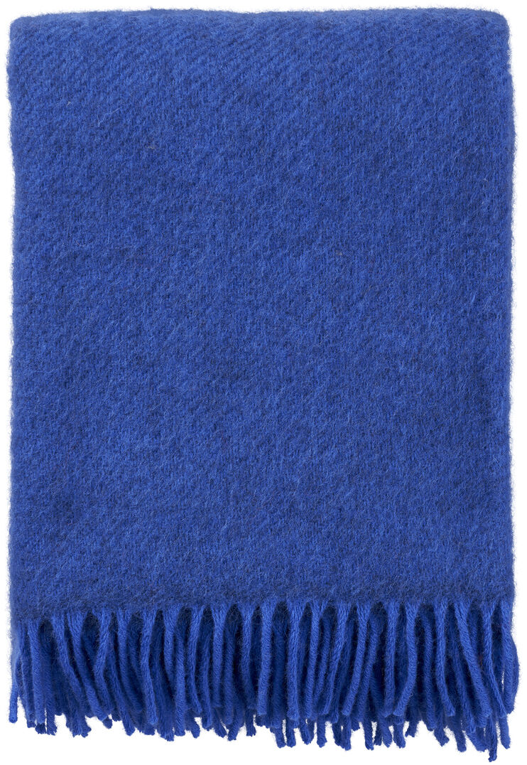 Eine blaue Decke aus Wolle mit Fransen, sauber zusammengefaltet vor einem weißen Hintergrund.