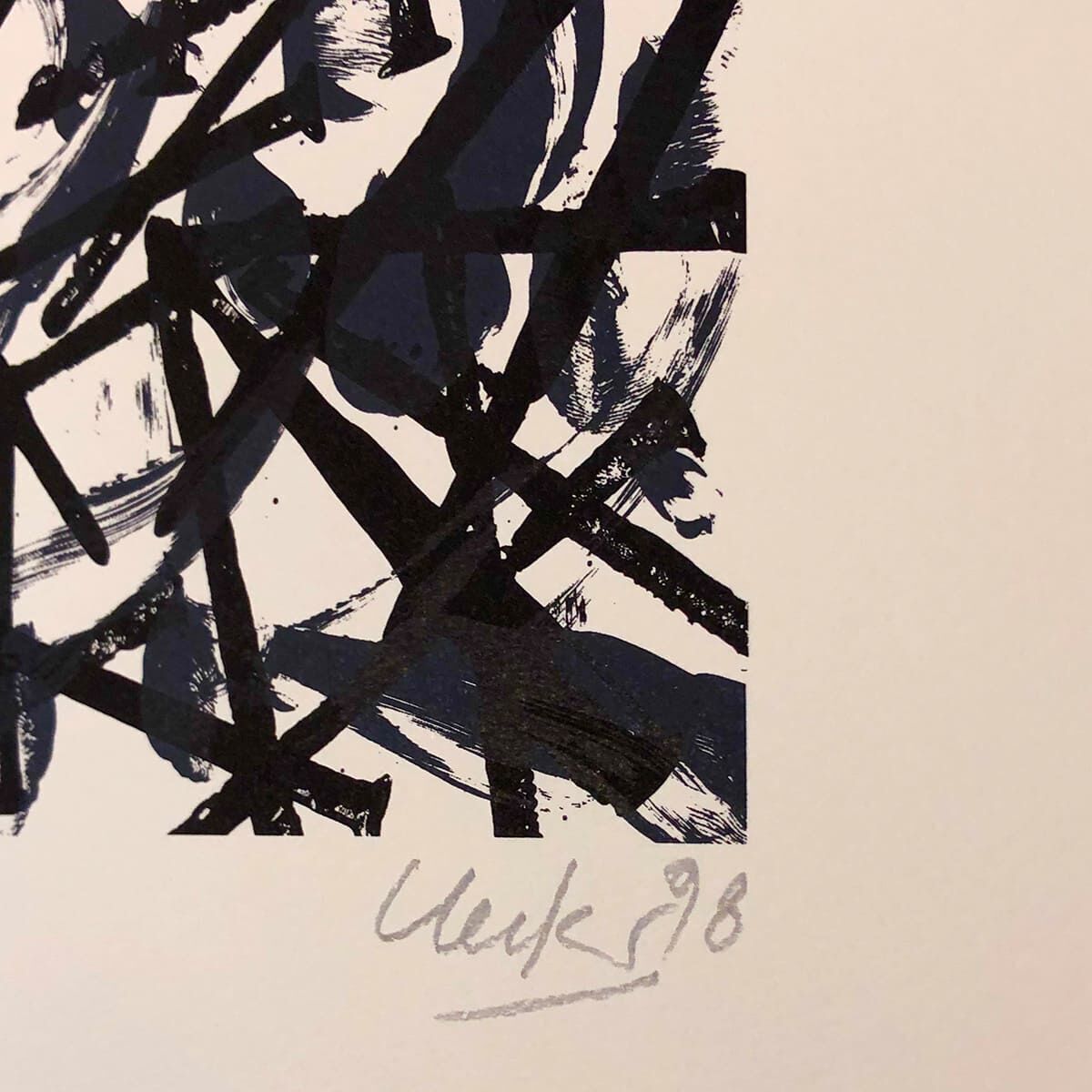 Abstraktes Kunstwerk von Günther Uecker mit schwarzen Linien und dicken Pinselstrichen auf weißem Hintergrund. Signiert mit 'Uecker 98'.