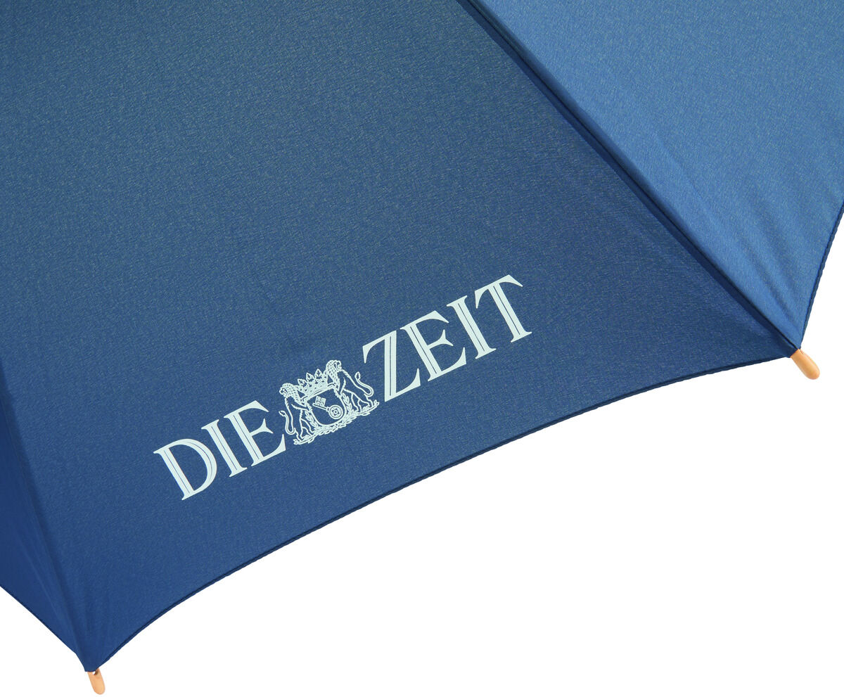 Blauer Regenschirm mit weißem Schriftzug 'Die ZEIT' und einem Emblem darunter.
