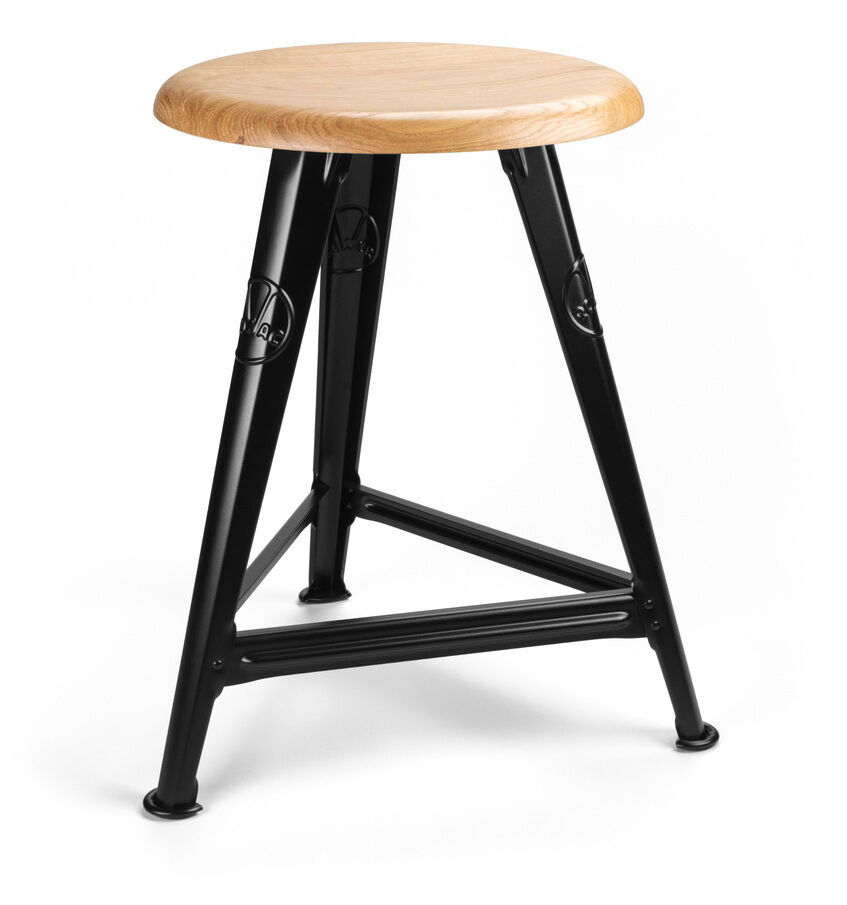 Der Rowac-Schemel ist ein hochwertiger Hocker mit einer runden Sitzfläche aus Eichenholz und einem mattschwarzen Metallgestell. Er hat ein minimalistisches und industrielles Design, das für verschiedene Wohn- oder Arbeitsumgebungen geeignet ist.