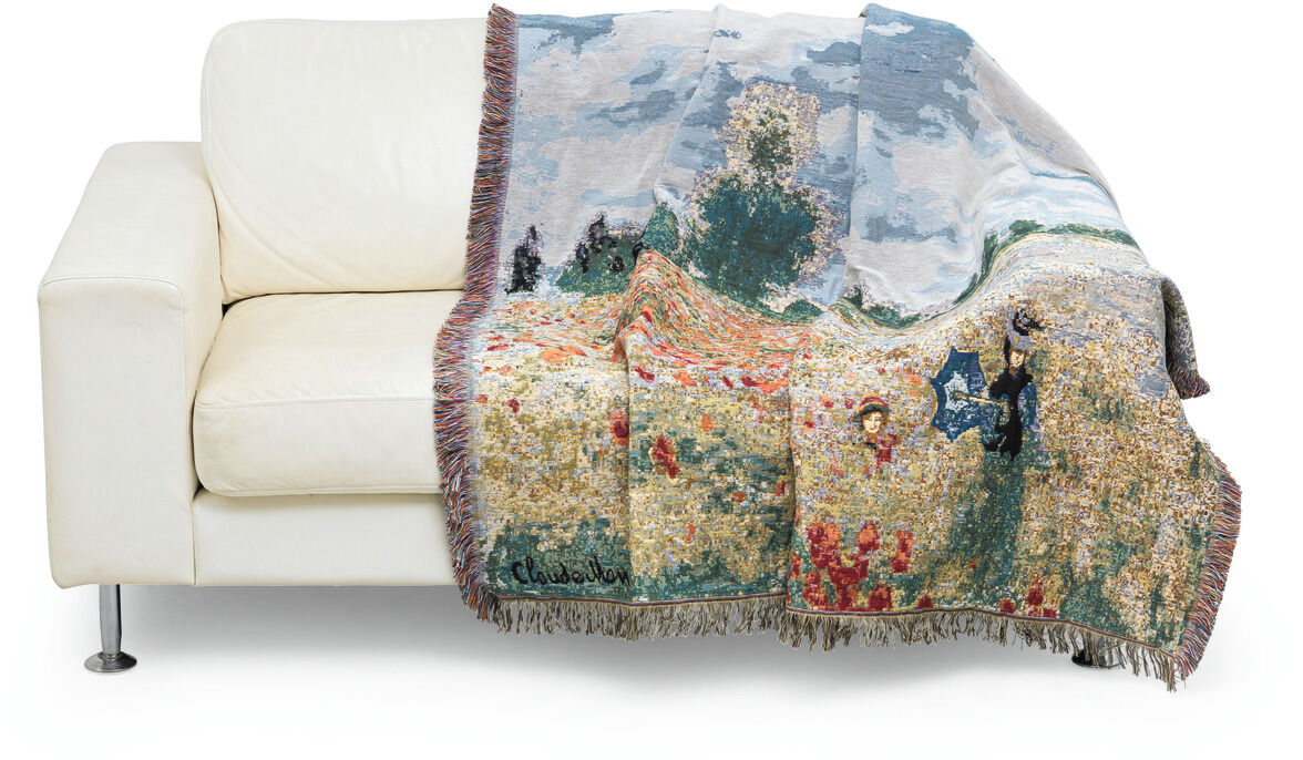 Wohnplaid »Les coquelicots à Argenteuil« nach Monet, drapiert über einem weißen Sofa. Das Design zeigt ein impressionistisches Gemälde mit Blumenwiese und Figuren.