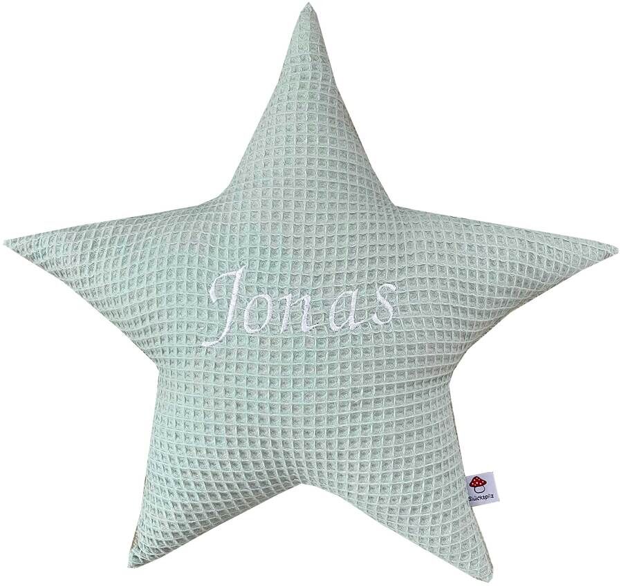 Ein weiches, sternförmiges Kissen mit der Aufschrift 'Jonas' in der Mitte, gestrickt in hellgrüner Farbe. Ideales personalisierbares Geschenk für Kinderzimmer oder als Dekoration.