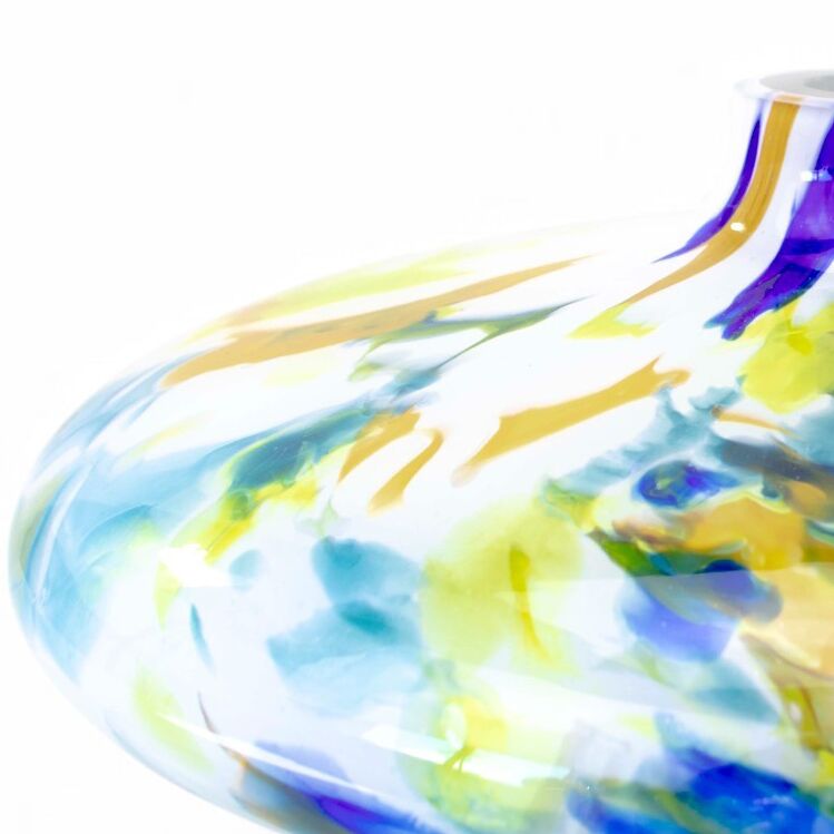Detailansicht einer farbenfrohen Glasvase namens „Lunor“ der Marke Ars mundi mit runden, weich ineinander verlaufenden Farben in Weiß, Gelb, Blau, Grün und Lila. Die Oberfläche glänzt, der obere Abschluss ist schmal geformt.
