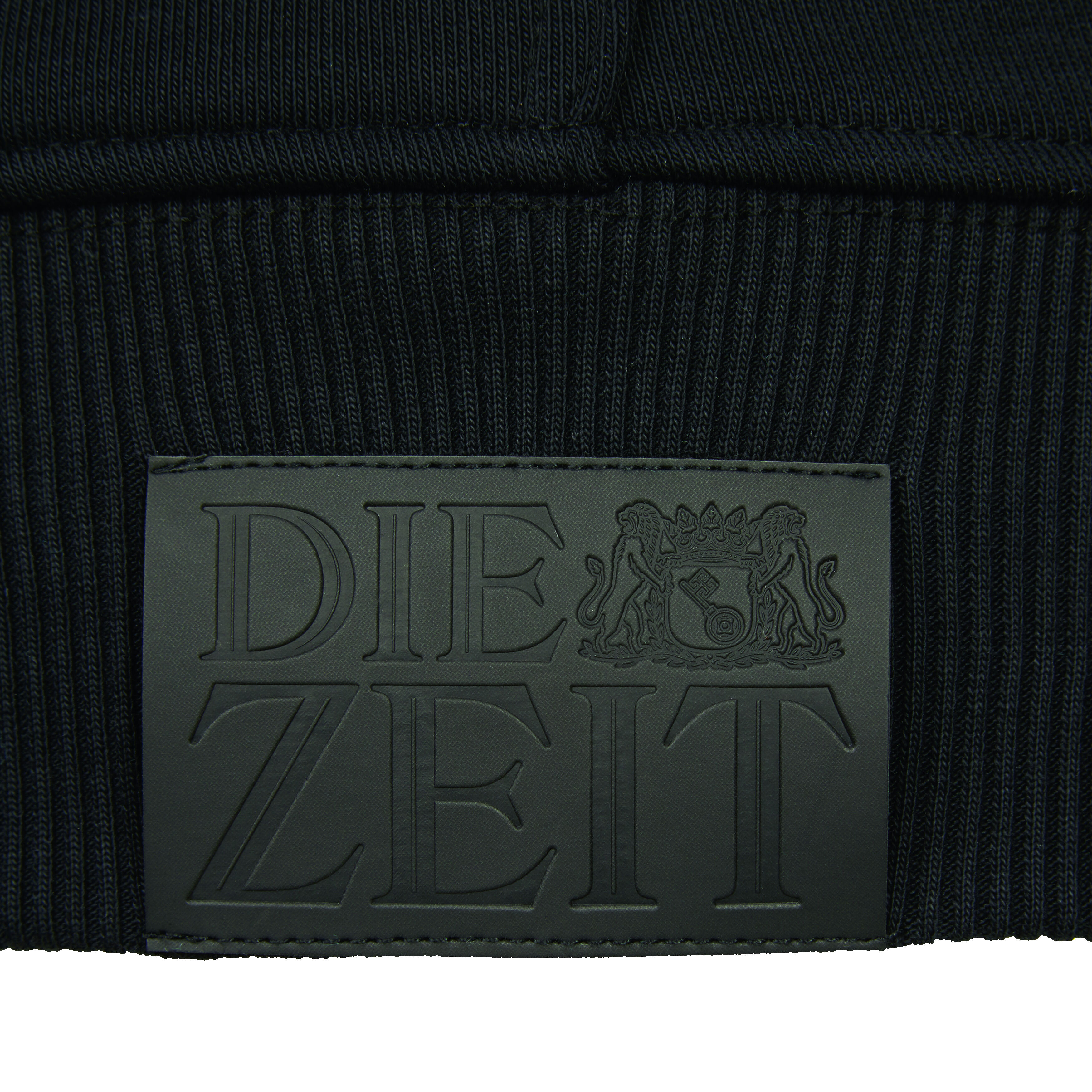 Nahaufnahme eines schwarzen Hoodies aus der ZEIT-Kollektion mit dem aufgestickten DIE ZEIT-Logo auf der Vorderseite.