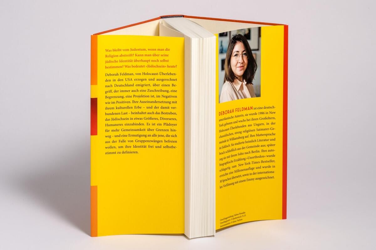 Das Bild zeigt das Buch 'Judenfetisch' von Deborah Feldman. Das gelbliche Buchcover umfasst die Rückseite und einen Teil der Frontseite des aufgeschlagenen Buches. Auf der Rückseite ist ein Porträt von Deborah Feldman abgebildet.