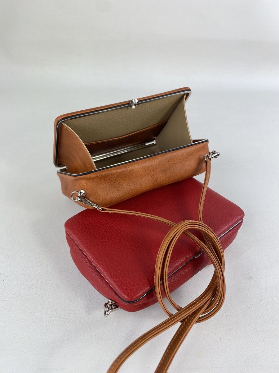 Handtasche ZEIT-Tasche »Jacky« in rotem und braunem Leder, mit einer Innentasche und einem Schulterriemen aus Leder, platziert auf einem hellen Hintergrund.