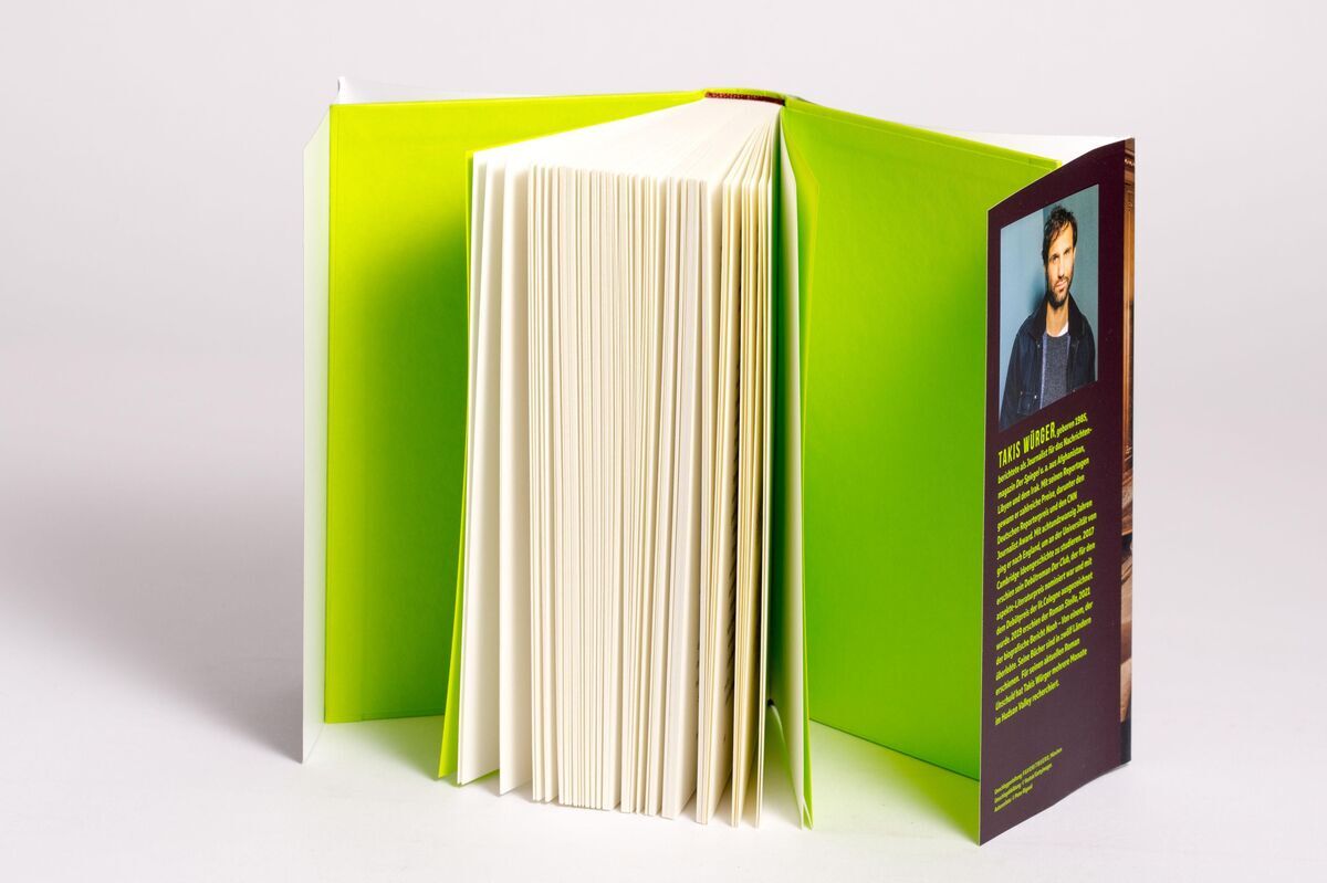 Das Bild zeigt das Buch 'Würger, Takis: Unschuld'. Das Buch hat einen grünen Einband. Es ist teilweise geöffnet und seitlich liegt ein Lesezeichen, auf dessen Rückseite ein Bild des Autors zu sehen ist. Das Papier der geöffneten Seiten ist weiß.