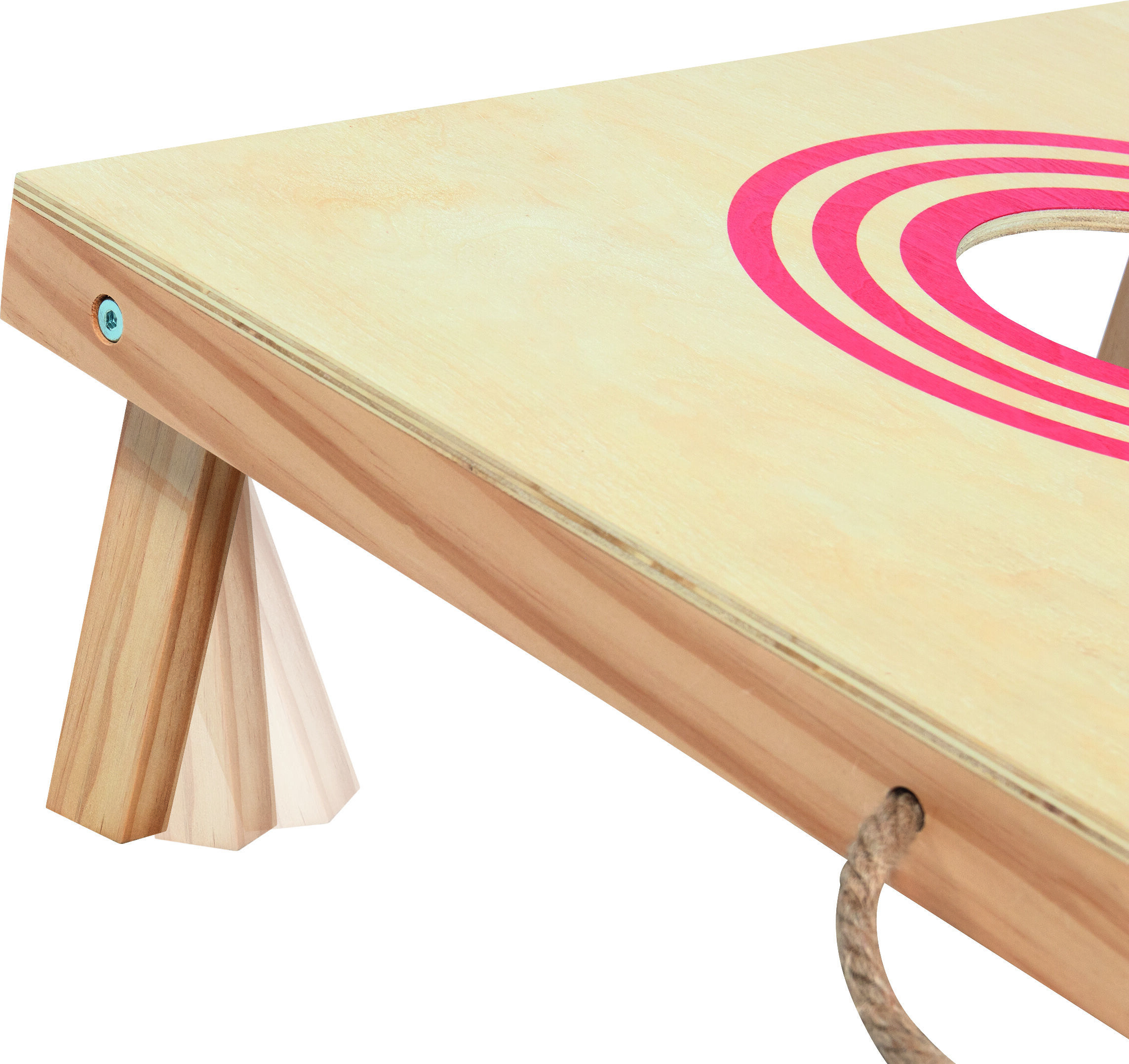 Teilansicht eines Wurfspiels vom Typ Cornhole mit einer schrägen Holzplatte, in die ein rundes Loch eingelassen ist. Um das Loch herum verläuft ein auffälliger pinkfarbener Kreis. Das Brett steht auf klappbaren Holzbeinen, geeignet für Outdoor-Aktivitäten und Freizeitspiele.