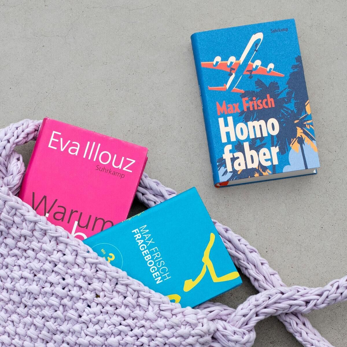 Ein buch mit dem Titel 'Warum Liebe weh tut' von Eva Illouz ist teilweise in einer gestrickten Tasche zu sehen, begleitet von zwei weiteren Büchern, 'Homo Faber' und 'Fragebogen' von Max Frisch.