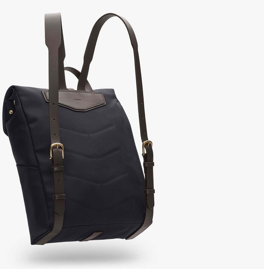 Ein stilvoller Rucksack von MISMO aus schwarzem Canvas mit braunen Lederdetails und zwei verstellbaren Schulterriemen. Der Rucksack hat einen minimalistischen und funktionalen Designansatz, geeignet für den täglichen Gebrauch.