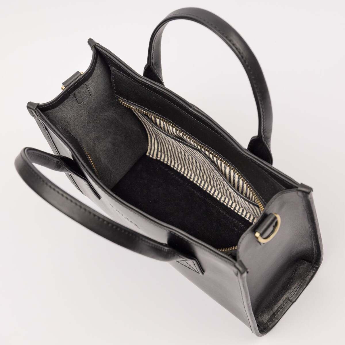 Offene schwarze Handtasche in Lederoptik mit zwei Henkeln, großem Hauptfach und goldfarbenen Reißverschlussdetails, fotografiert auf hellem Hintergrund.